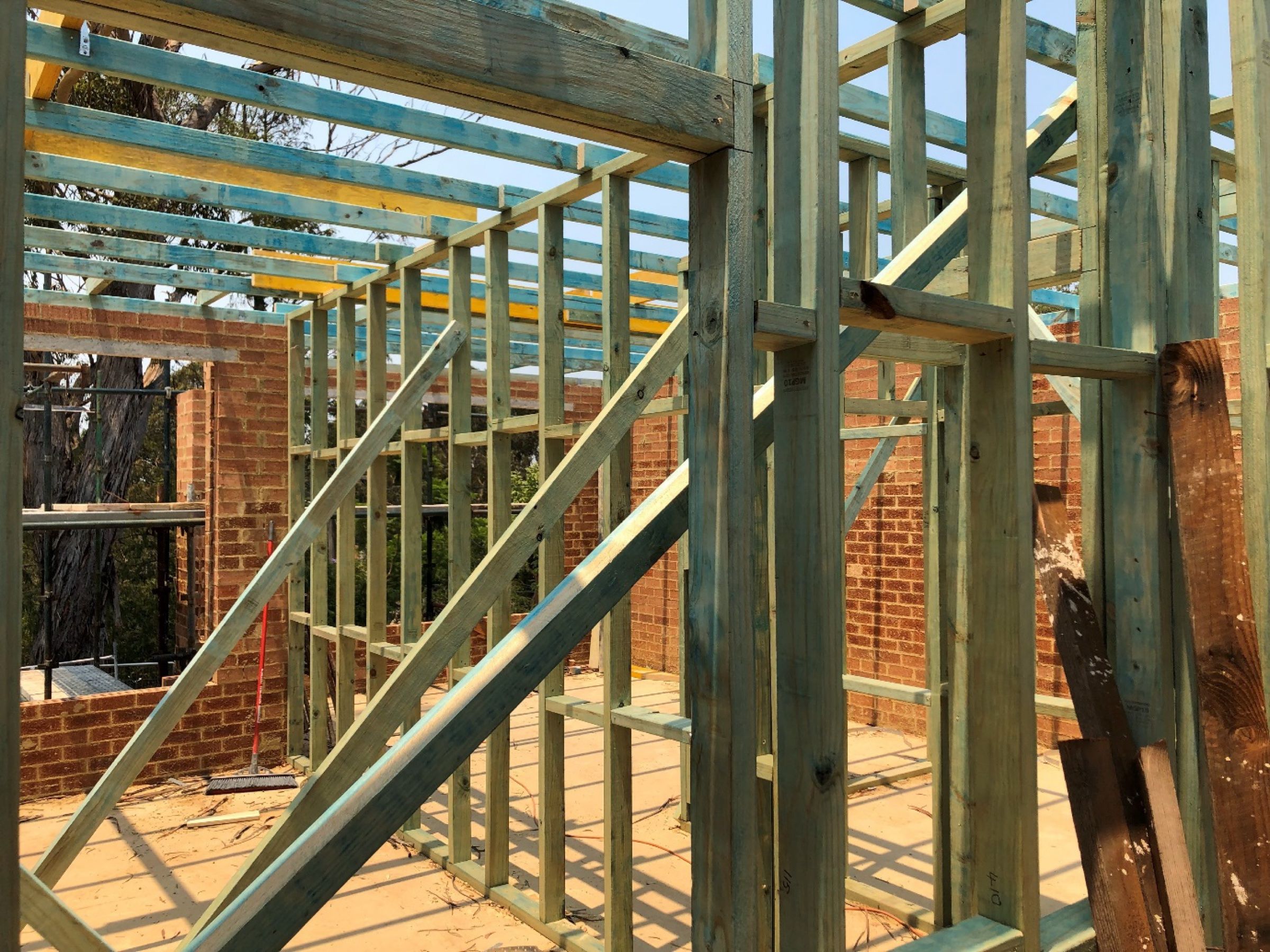 Timber wall and roof framing going up inside a brick double-storey build